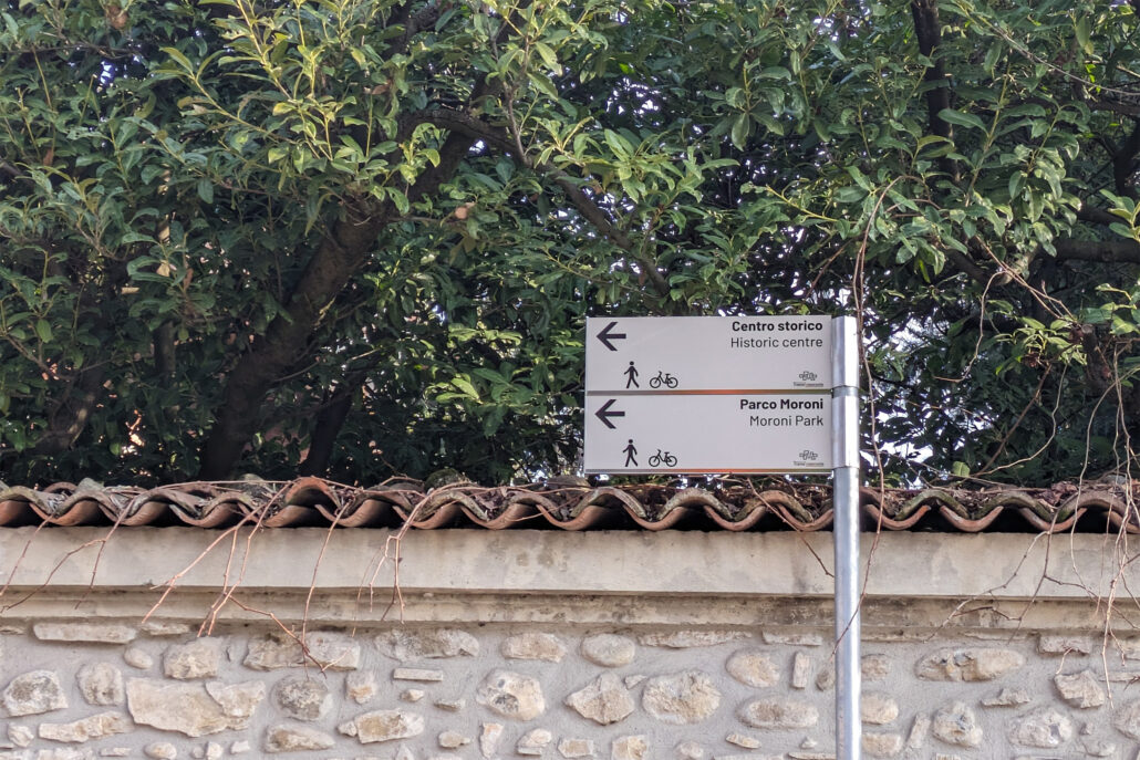 vista di due cartelli stradali direzionali con indicazione del centro storico e del Parco Maroni, con la grafica del progetto ed il logo di "trame nascoste"